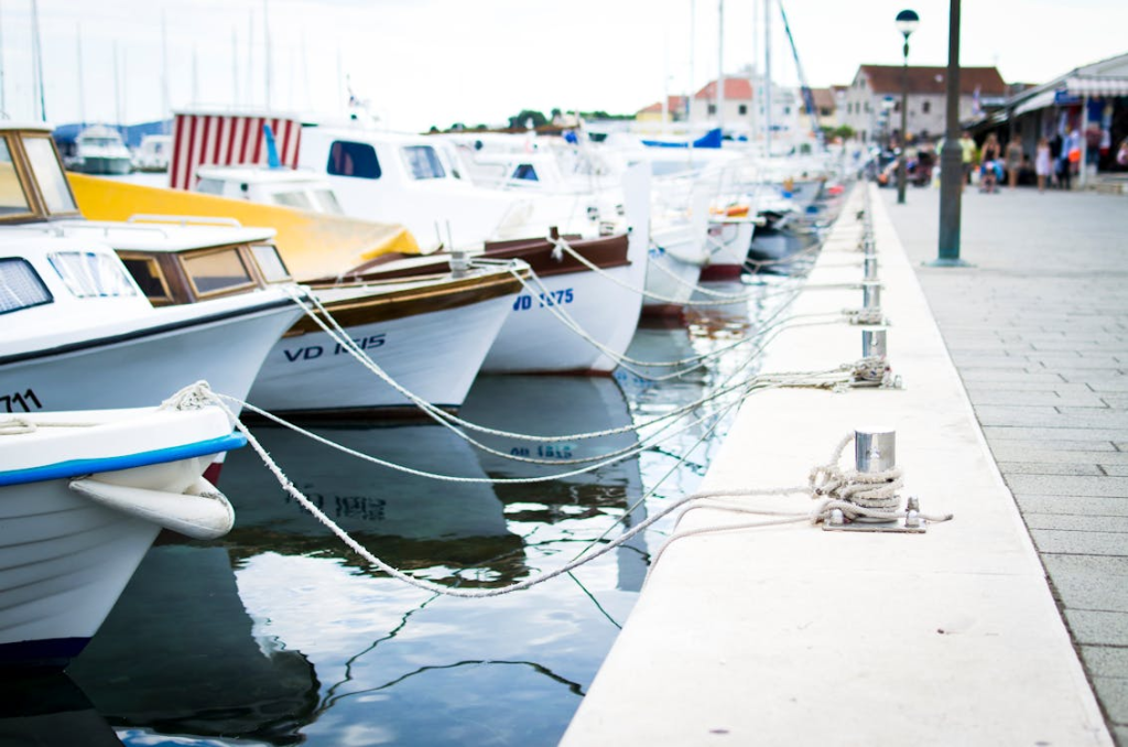 A collection of boats moored at a harbor pier on a clear day.