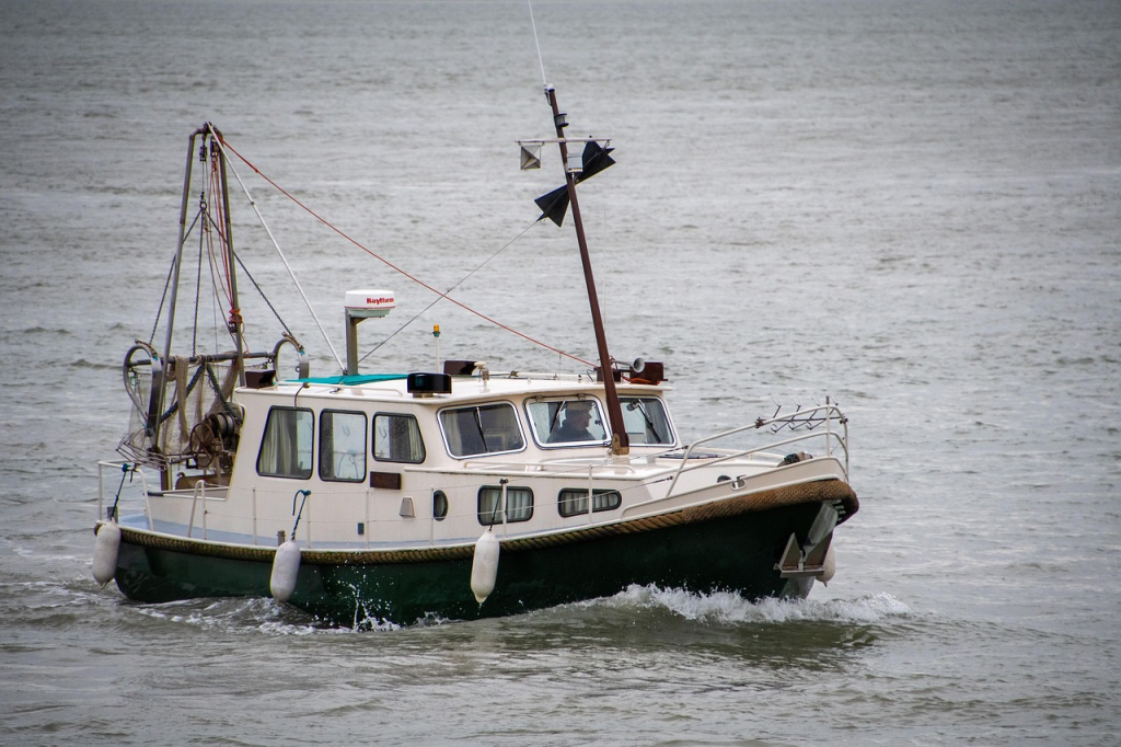 Small commercial fishing boat operating at sea under clear skies
