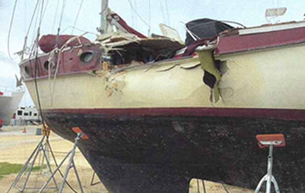A large red, white and black boat parked at shore.