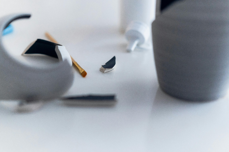 a broken vase lying on a white surface
